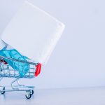 A Roll Of White Toilet Paper And Sanitizer In A Shopping Cart